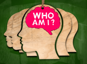 Drie getekende hoofden van de zijkant met in het midden in de hersenen de tekst: wie ben ik?