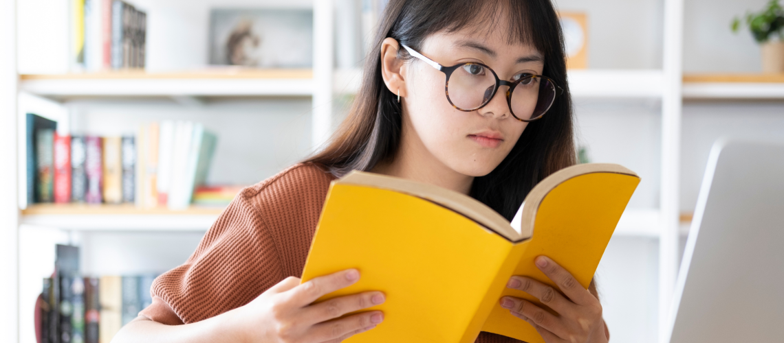 Vrouw aan het dtuderen. ze heeft ene bril op en leest een boek: zelfstudie